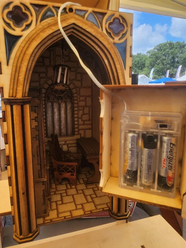 A miniature church with a small organ and a cell phone.