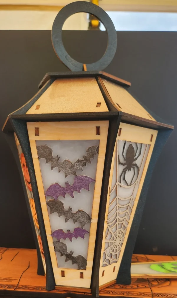 A lantern with bats, spiders and spider webs.