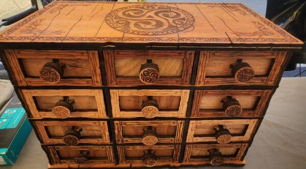 A wooden chest of drawers with some design on it