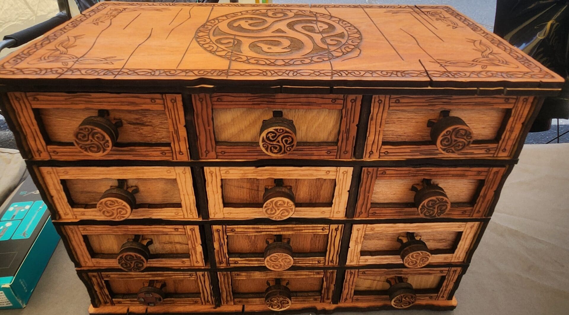 A wooden chest of drawers with some design on it