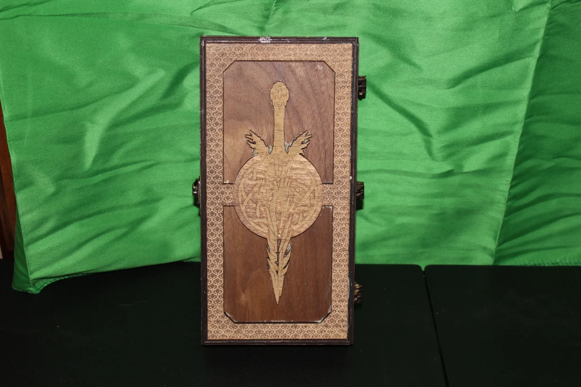 A wooden box with a sword on it