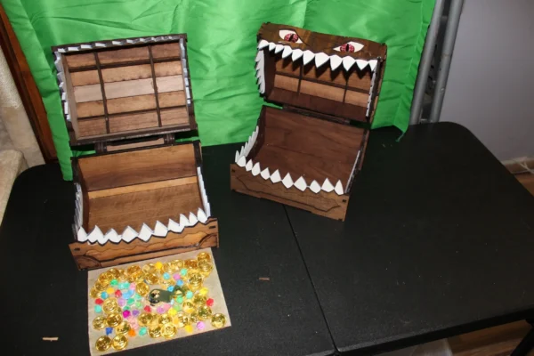 Two boxes with a mouth on them and candy in the middle.