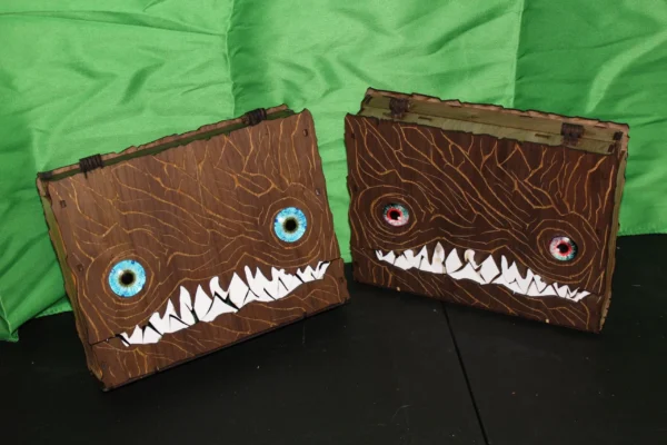 Two boxes with faces made of paper and paint.