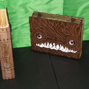 A wooden box with an evil face on it.